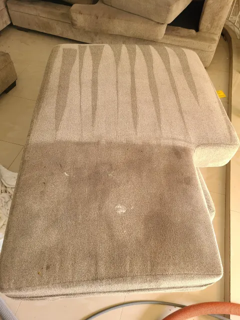 Sofa cushion half cleaned to show the difference