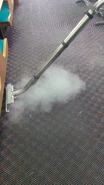 Steam rising from a commercial carpet during hot-water extraction